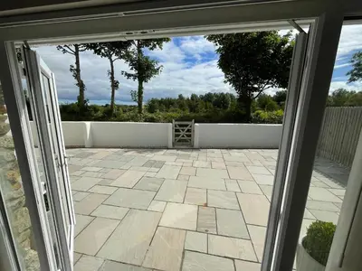 a sliding glass door looking out onto a patio at Sunnyside Cow Shed one bedroom central Cornwall in Truro
