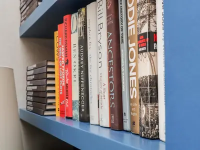 a row of books on a blue shelf at The Water House in Falmouth