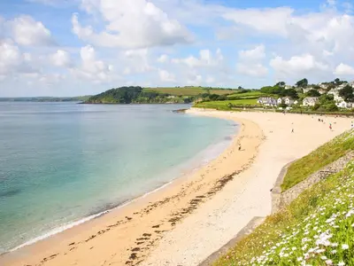 a beach in ireland with people walking on it at The Water House in Falmouth