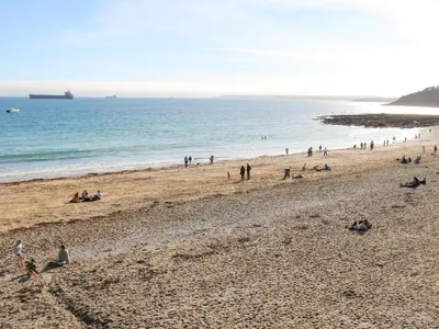 a group of people on a beach near the ocean at The Water House in Falmouth
