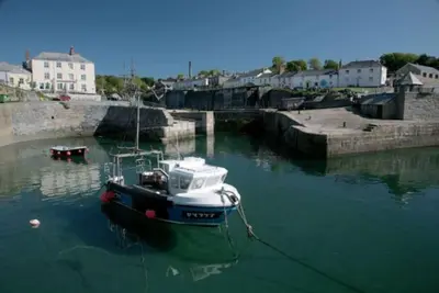 a boat is docked in a body of water at The Captain's House Charlestown St Austell in Charlestown