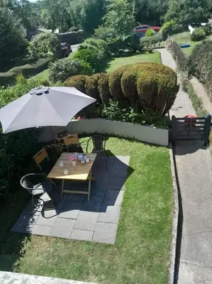 a picnic table with an umbrella in the grass at The Captain's House Charlestown St Austell in Charlestown