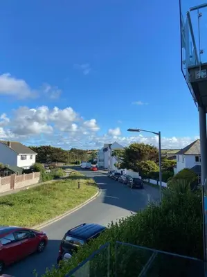 a street with cars parked on the side of the road at Lovely 2 Bedroom flat moments from Fistral Newquay in Newquay