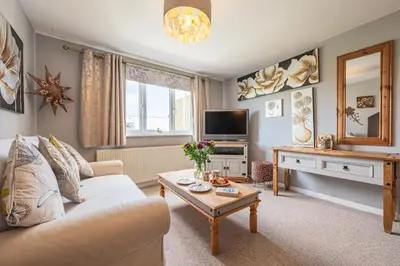 a living room with a couch and a table at Deerpark, Guest House in Padstow