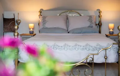 a bedroom with a white bed with two pillows at Deerpark, Guest House in Padstow