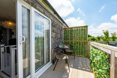 a patio with a table and chairs on a balcony at Deerpark, Guest House in Padstow