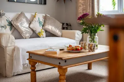 a living room with a white couch and a coffee table at Deerpark, Guest House in Padstow