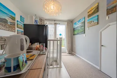 a kitchen with a counter with a tv and a refrigerator at Deerpark, Guest House in Padstow