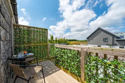 a balcony with a table and a fence at Deerpark, Guest House in Padstow