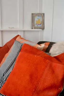 a bed with an orange blanket on top of it at Sunny Corner in Port Isaac