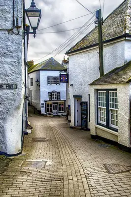 an empty cobblestone street in a town with buildings at Sunny Corner in Port Isaac