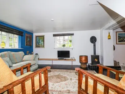 a living room with a couch and a fireplace at The Cottage in Bodmin