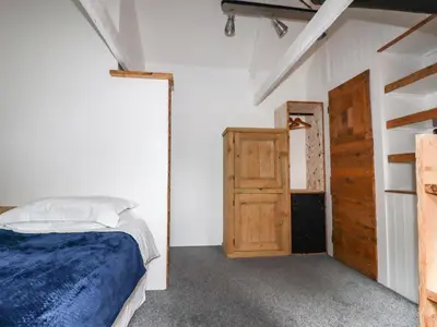 a bedroom with a bed and an open door at The Cottage in Bodmin