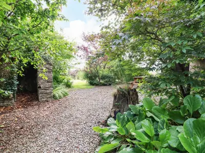 a gravel path in a garden with trees at The Cottage in Bodmin