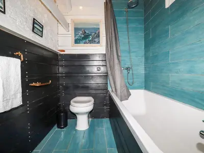 a bathroom with a toilet and a bath tub at The Cottage in Bodmin