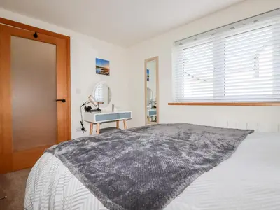 a bedroom with a bed and a window and a desk at Clonmore in Bodmin