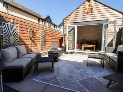 a patio with a couch and chairs and a table at Clonmore in Bodmin