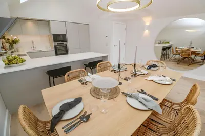 a dining room with a wooden table and chairs at Porth Beach in Newquay