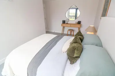 a bedroom with a bed with a pillow on it at Porth Beach in Newquay