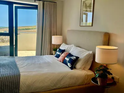 a bedroom with a bed with two pillows and a window at Porth Beach in Newquay