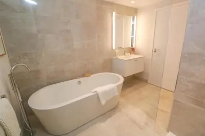 a bathroom with a white bath tub and a sink at Porth Beach in Newquay