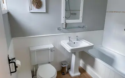a white bathroom with a sink and a toilet at Brakestone Cottage in the heart of Port Isaac in Port Isaac