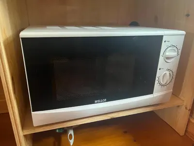 a microwave oven sitting on a wooden shelf at The Hobbit Hole in Zelah