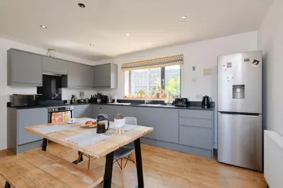 a kitchen with a wooden table and a refrigerator at Finest Retreats - Seadog in Porthleven