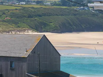 a building next to a beach with the ocean at The Sandbox in Hayle