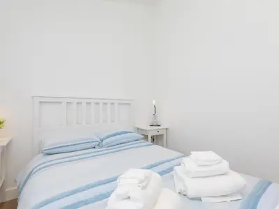 a bedroom with a bed with towels on it at The Sandbox in Hayle