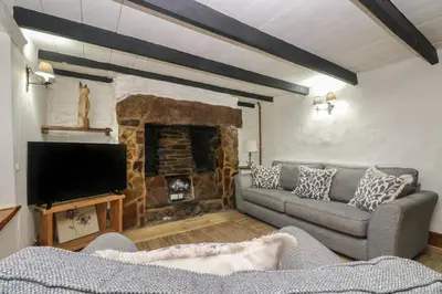 a living room with a couch and a fireplace at Myrtle Cottage in Hayle