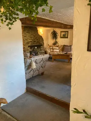 a living room with a stone fireplace and a couch at Bissick Old Mill Suite in Truro