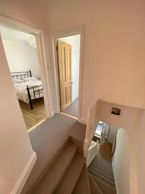 a hallway with a staircase leading to a bedroom at Beautiful 2 bed end terrace Victorian town house in Redruth