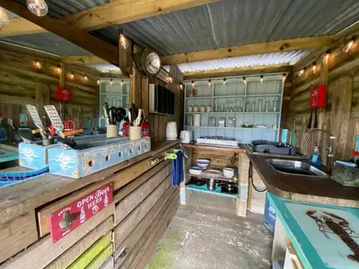 a kitchen with wooden walls and a counter with a sink at Stunning views & sunrises from Sally Saracen in St Ives