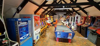 a room with arcade games and a table in the middle at 3 Manor Villas Newquay in Newquay