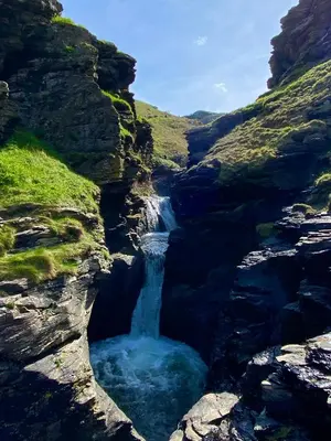 a waterfall in the middle of a rocky canyon at Polrunny Farm sea view Blueberry Cottage with log burner in Boscastle