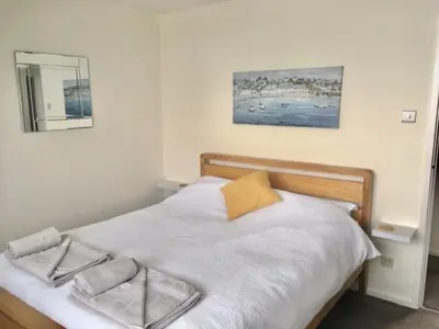 a bedroom with a bed with two towels on it at Seymour Apartment - Looe in Looe