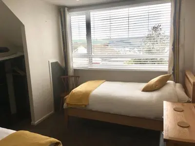 a bedroom with a bed and a large window at Seymour Apartment - Looe in Looe
