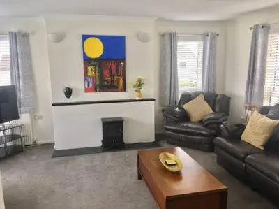 a living room with a couch and a fireplace at Seymour Apartment - Looe in Looe