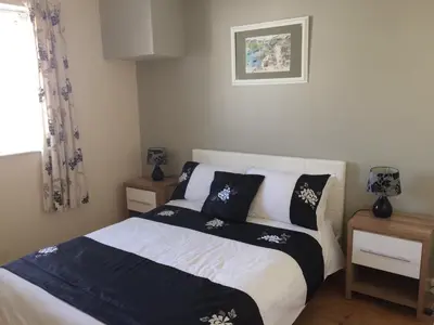 a bedroom with a bed with black and white pillows at Towan Beach Holiday Flat in Newquay