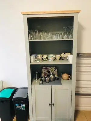 a white cabinet with a lot of dishes in it at Towan Beach Holiday Flat in Newquay