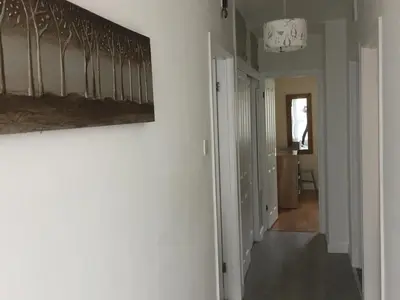 a hallway with a painting hanging on a wall at Towan Beach Holiday Flat in Newquay