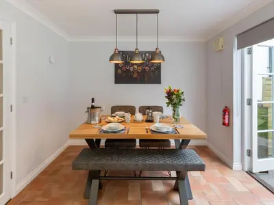 a dining room with a wooden table and chairs at Holiday Home Sea Echo by Interhome in St Austell