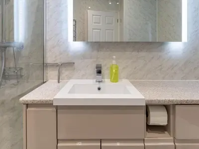 a bathroom with a white sink and a mirror at Holiday Home Sea Echo by Interhome in St Austell