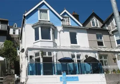 a large white house with blue windows at Shellseekers Guest House in Looe