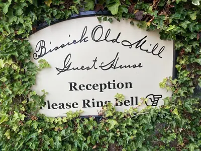 a sign covered in ivy at a wedding at Bissick Old Mill in Truro