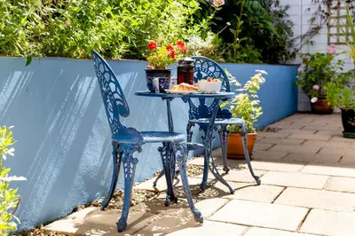 two blue chairs and a table with food on it at The Old Coastguard Station in Falmouth