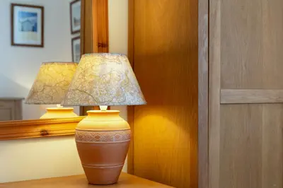 a brown vase sitting on a table with a lamp at The Old Coastguard Station in Falmouth