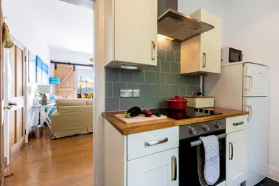 a kitchen with white cabinets and a stove at The Old Coastguard Station in Falmouth