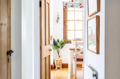 an open door to a dining room with a table at The Old Coastguard Station in Falmouth